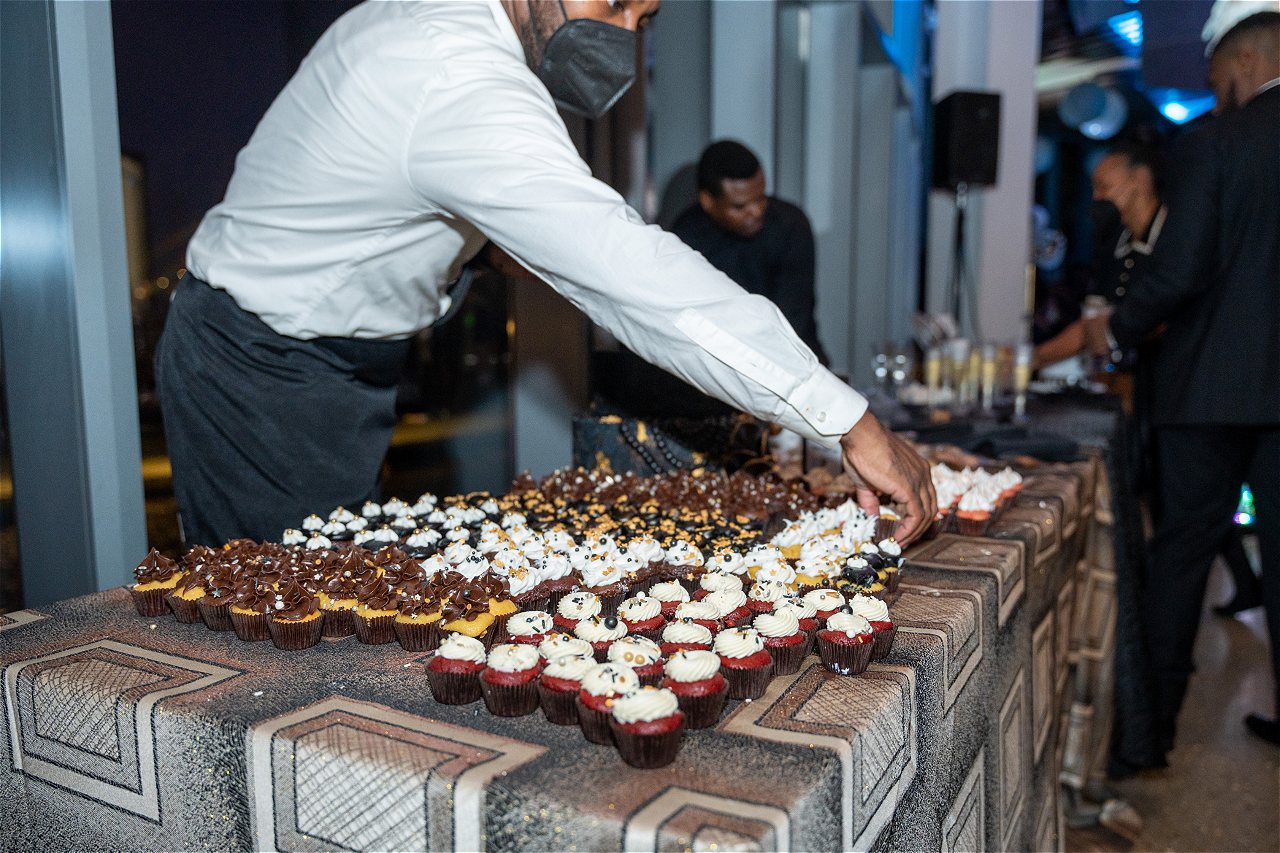 A waiter setting out the midnight desert bar at Capital Gatsby New Year's Eve DC Gala at HQO
