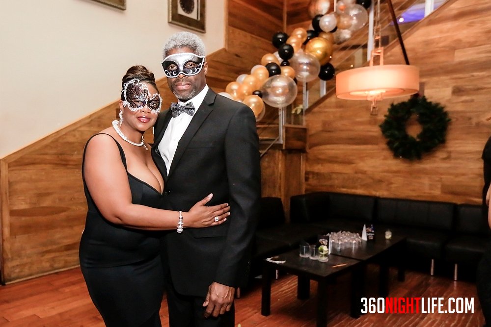 Beautiful African American couple at National New Year's Eve Masquerade Ball presented by 360 Nightlife in Washington, DC. The longest running NYE event in the Nation's Capital. There is a VIP table in the background.