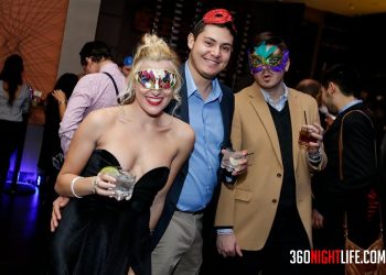 1 woman in a black dress showing off her leg and 2 men standing next to her. All 3 have masquerade masks. The woman is on the right and is wearing the mask the guy in the middle has a blue shirt and his masquerade mask is sitting on top of his head. The man on the far right has his masquerade mask on and it is colorful. This picture was taken at National New Year's Eve Masquerade Ball by 360 Nightlife in Washington, DC. The original website was http://www.360nightlife.com but we have revamped to https://www.360nigthlife.com. Please note: all rights reserved. These photos are sole copyright of 360 Nightlife & should not be used without permission or attribution.