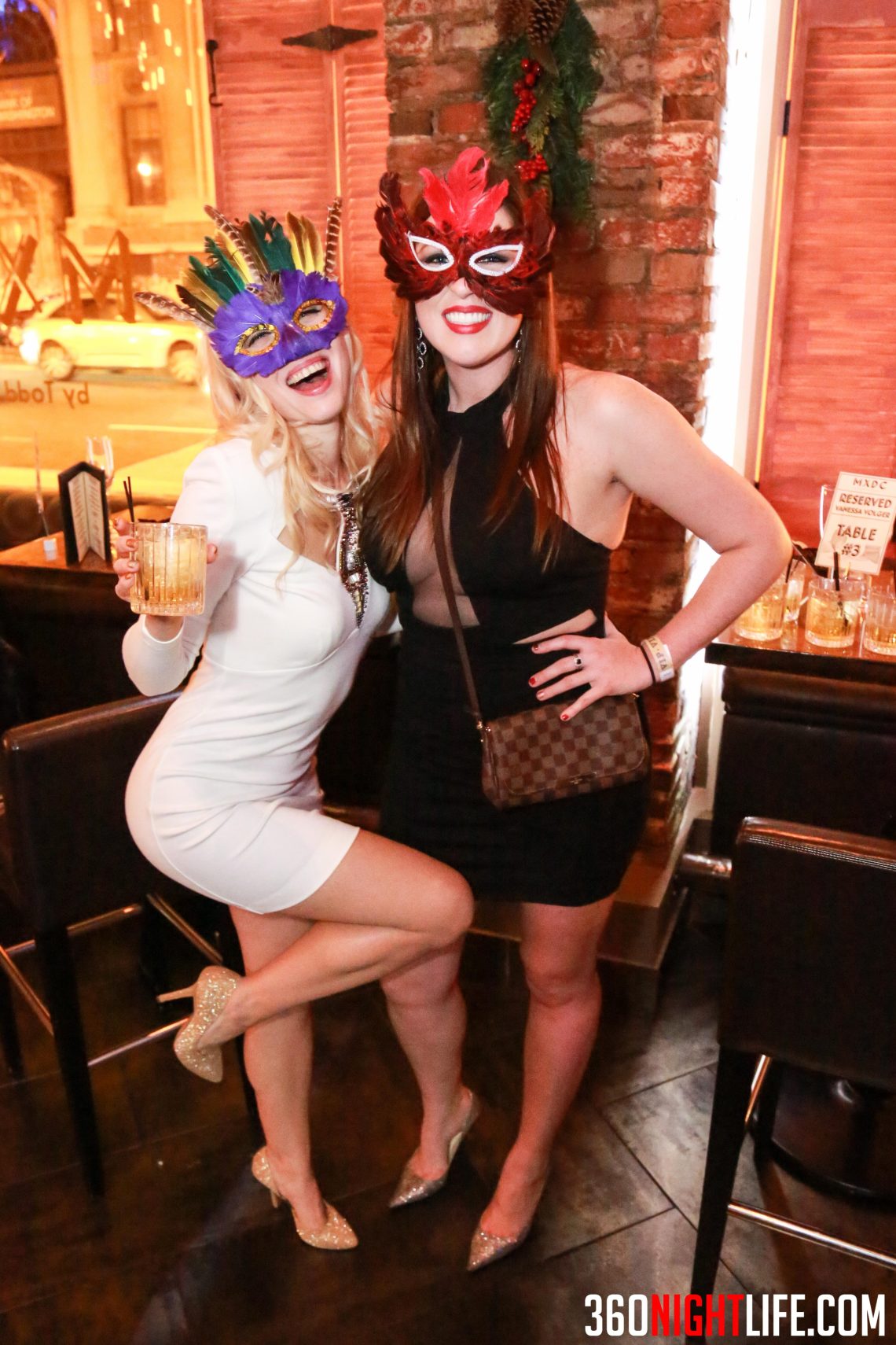 2 young women at the National New Years Eve Masquerade Ball in Washington DC. They have colorful masks on with feathers. This was at an event hosted by 360 Nightlife and its a very famous NYE party.